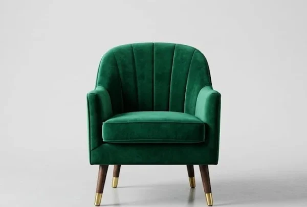 A professionally lit emerald green velvet armchair centered on a neutral gray background.
